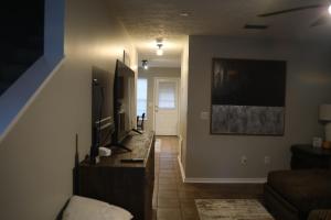 a living room with a couch and a flat screen tv at #HycheHoops Final Four Nest in Starkville