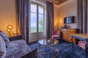 a hotel room with a couch and a table and a window at Domaine De La Corniche in Rolleboise