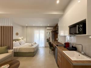 a bedroom with a bed and a kitchen with a sink at Blue Tree Suites in Pefkochori