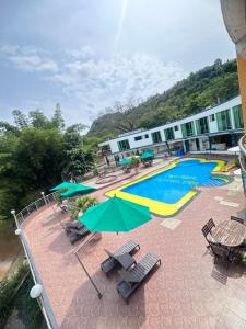 a resort with a swimming pool with chairs and umbrellas at Hotel Cristalina in Melgar