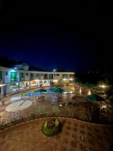 a resort at night with a pool and umbrellas at Hotel Cristalina in Melgar +26 photos