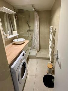 a bathroom with a washing machine and a sink at Large Studio Near Train station and Disney in Lognes