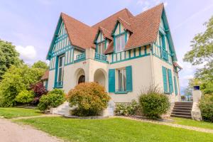 a blue and white house with a brown roof at Domaine De La Corniche in Rolleboise