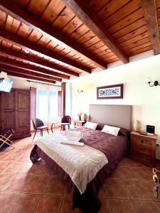 a bedroom with a large bed and a wooden ceiling at Hostal El Rincón del Trillo in La Alberca