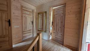 a log home hallway with wooden walls and wooden floors at Sarnia CHATA in Brenna