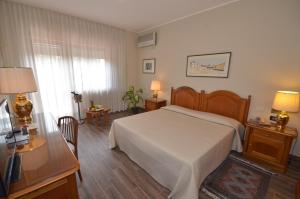 a bedroom with a bed and a desk and a television at Garden Rooms in San Giovanni la Punta