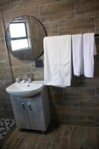 a bathroom with a sink and a mirror and towels at Lifestyle Villas in Sipilini