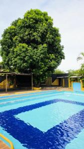 a large blue swimming pool with a tree in the background at Ypane Residencial in Ypane