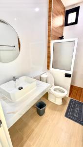 a bathroom with a white sink and a toilet at Minimo Hotel - โรงแรมมินิโม กุมภวาปี in Amphoe Kumphawapi