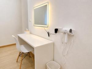 a room with a white desk and a phone on the wall at Minimo Hotel - โรงแรมมินิโม กุมภวาปี in Amphoe Kumphawapi