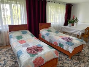 two beds sitting next to each other in a room at Bugu Too Guest House in Kaindy