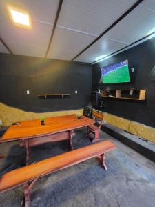 a room with a table and a tv on a wall at Ypane Residencial in Ypane