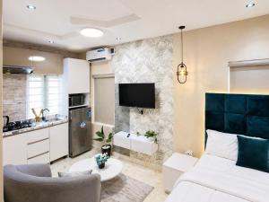 a living room with a bed and a kitchen at Happy Lodge Shortlets & Suites, Freedom Way, Lekki phase 1 in Ogoyo
