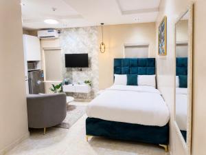 a bedroom with a large bed and a chair at Happy Lodge Shortlets & Suites, Freedom Way, Lekki phase 1 in Ogoyo
