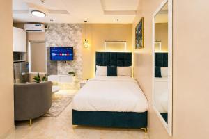 a bedroom with a bed and a couch and a television at Happy Lodge Shortlets & Suites, Freedom Way, Lekki phase 1 in Ogoyo