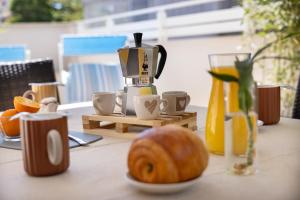 a table with a juicer and a bowl of fruit on it at The Iconic Ceccarini - Riviera Collection in Riccione +32 photos