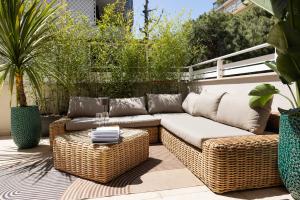 a wicker couch and a table on a patio at The Iconic Ceccarini - Riviera Collection in Riccione