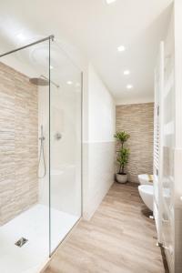 a bathroom with a glass shower and a toilet at The Iconic Ceccarini - Riviera Collection in Riccione