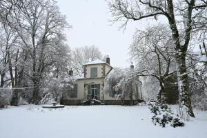 an old house covered in snow in a yard at Le Manivert in Vitry-Laché
