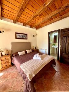 a bedroom with a large bed and a wooden ceiling at Hostal El Rincón del Trillo in La Alberca