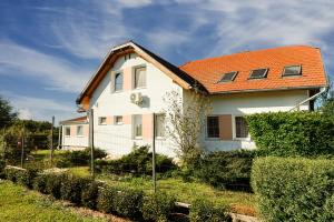 a white house with an orange roof at Anna Vendégház Szeleste in Szeleste
