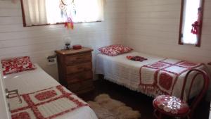 a bedroom with two beds and a wooden dresser at MauMari in Tigre