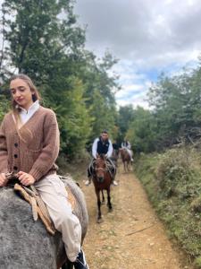 a woman riding a horse on a path with people on horses at Hagvi Resort in Alaverdi