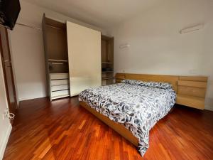 a bedroom with a bed and a wooden floor at Maison de l'Eau by Lago Maggiore Rentals in Verbania +25 photos