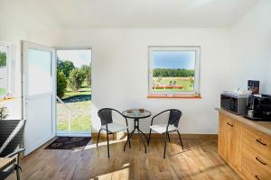 a kitchen with a table and two chairs and a window at Anna Vendégház Szeleste in Szeleste