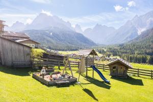 a group of people in a field with a playground at Gesenhof in Sesto