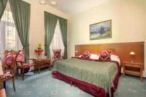 a hotel room with a bed and a table and chairs at Green Garden Hotel in Prague