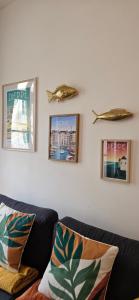 a living room with a couch and pictures on the wall at Les balcons de Dieppe - appartement 1ER étage - certifié 3 étoiles au cœur de la rue piétonne in Dieppe +21 photos