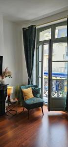 a living room with a chair and a window at Les balcons de Dieppe - appartement 1ER étage - certifié 3 étoiles au cœur de la rue piétonne in Dieppe
