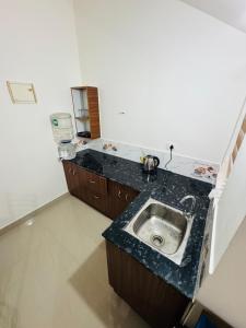 a kitchen with a black counter top with a sink at Iconic villas by ROYAL VILLAS in Athirappilly