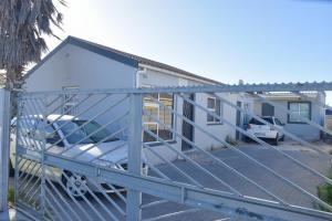 a garage with a car parked in front of a house at Silwood Heights Flatlet in Eerste River in Faure
