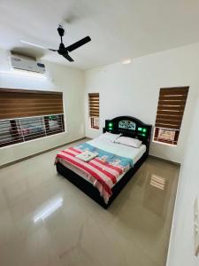 a bedroom with a bed and a ceiling fan at Iconic villas by ROYAL VILLAS in Athirappilly