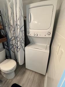 a white washer and dryer in a bathroom with a toilet at Chucks Cottage in Cape Charles in Cape Charles +4 photos