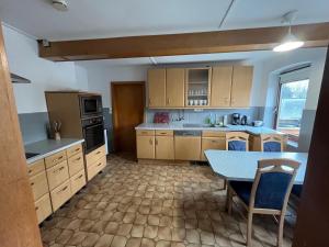 a kitchen with wooden cabinets and a table in it at Helles großes 2 Bettzimmer in Jerrishoe