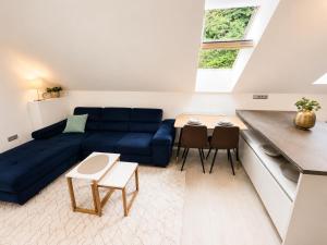 a living room with a blue couch and a table at Elysian apartment 1 in Trenčín