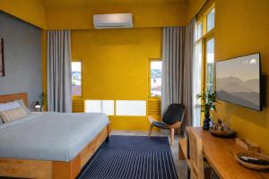 a hotel room with a bed and a chair and windows at Centerpoint Koh Phangan New in Thong Sala