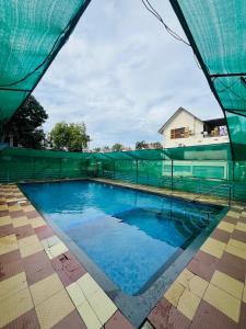 a swimming pool with a green fence around it at Iconic villas by ROYAL VILLAS in Athirappilly