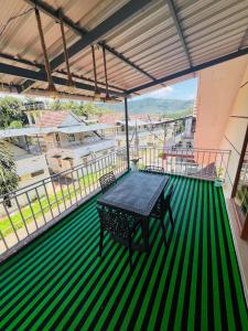 a green floor with a table and chairs on a balcony at Iconic villas by ROYAL VILLAS in Athirappilly