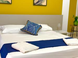 a white bed with two pillows on top of it at Taormina Naxos Home 2 in Giardini Naxos
