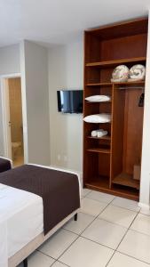 a bedroom with a bed and a shelf with plates at Rio Branco Hotel in Florianópolis