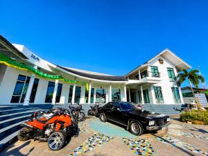 a motorcycle and a car parked in front of a house at Centerpoint Koh Phangan New in Thong Sala