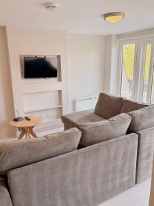 a living room with a couch and a tv at 105 beach lodge millendreath in Looe