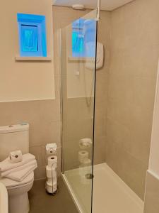 a bathroom with a shower and a toilet at 105 beach lodge millendreath in Looe +9 photos