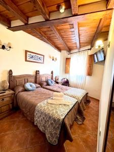 a bedroom with two beds and a table in it at Hostal El Rincón del Trillo in La Alberca