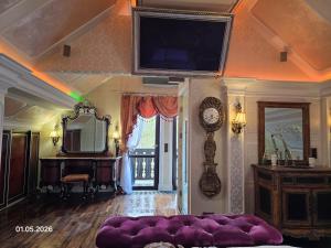 a living room with a large purple couch and a clock at PIOTROWSKi HOUSE in Ropica Górna