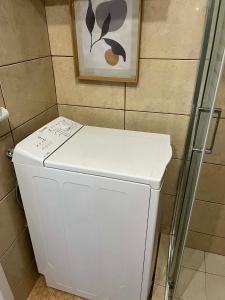 a white refrigerator in a bathroom with a picture on the wall at Hra in Loutraki